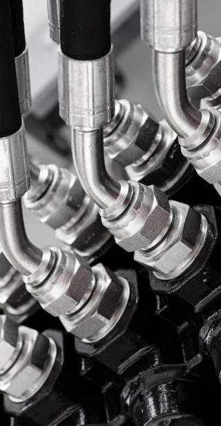 Hydraulic connectors in an industrial machine in close-up.